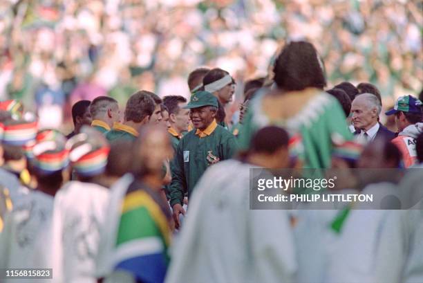 Picture taken on June 24, 1995 at Johannesburg showing South African President Nelson Mandela shaking hands with South African team members before...