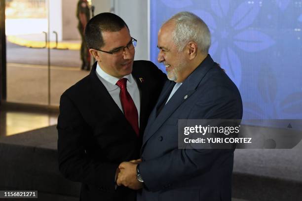 Venezuelan Foreign Minister Jorge Arreaza greets his Iranian counterpart Mohammad Javad Zarif upon arrival at a hotel for the opening ceremony of the...