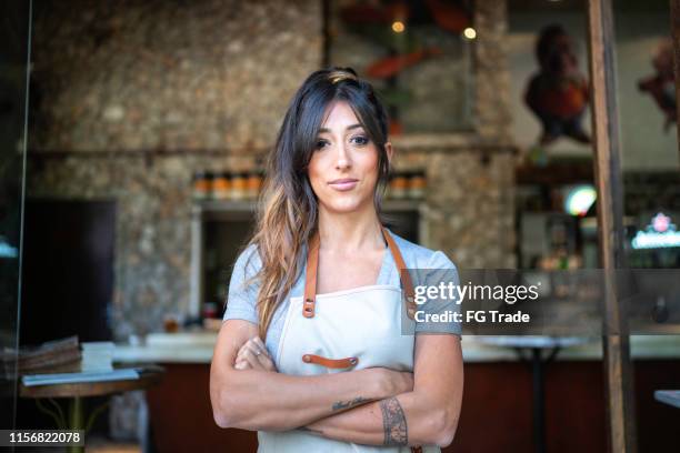 confident business owner standing at the entrance of a restaurant - woman tattoo stock pictures, royalty-free photos & images