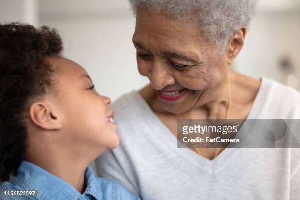 beautiful ethnic grandma is laughing with her young granddaughter. - great grandmother imagens e fotografias de stock