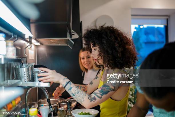 junge mitbewohner in der küche bereiten abendessen - roommate stock-fotos und bilder