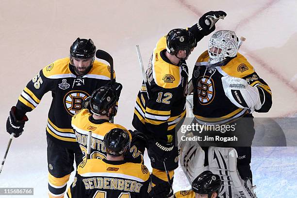 Tim Thomas of the Boston Bruins celebrates with his teammates Dennis Seidenberg, Johnny Boychuk and Tomas Kaberle after defeating the Vancouver...
