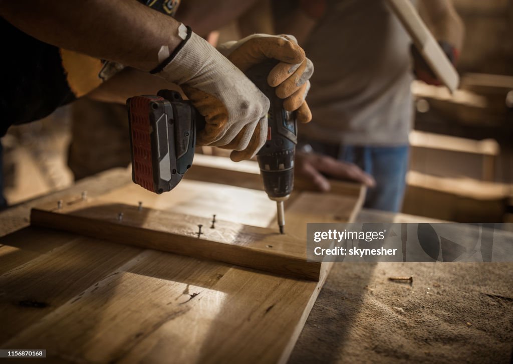 Close Up Of Manual Worker Using Drill While Making Furniture At ...