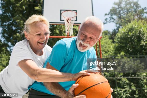 seniors having fun playing basketball - old basketball hoop stock pictures, royalty-free photos & images