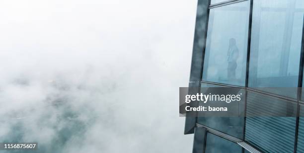 businessman standing in a skyscraper building viewing over the city - fog city stock pictures, royalty-free photos & images