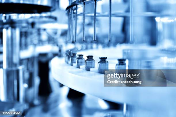 enchimento de garrafas de vidro na linha de produção - bioquímica - fotografias e filmes do acervo