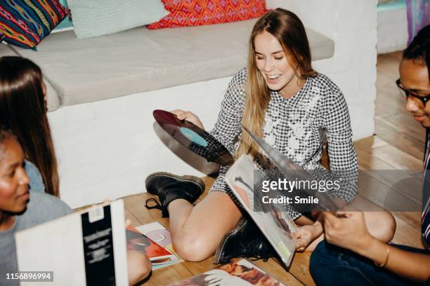group of young friends going through vinyls - personal stereo photos et images de collection