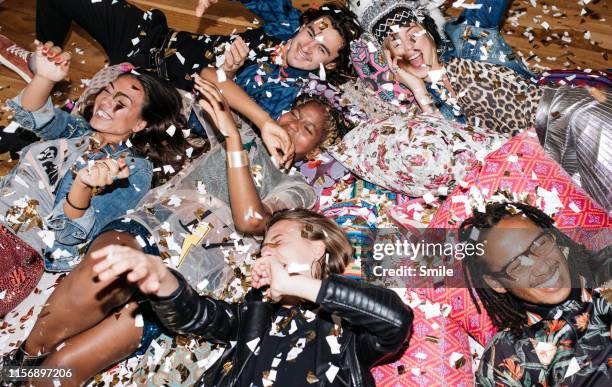 group of friends having fun with confetti on the floor - room after party fotografías e imágenes de stock