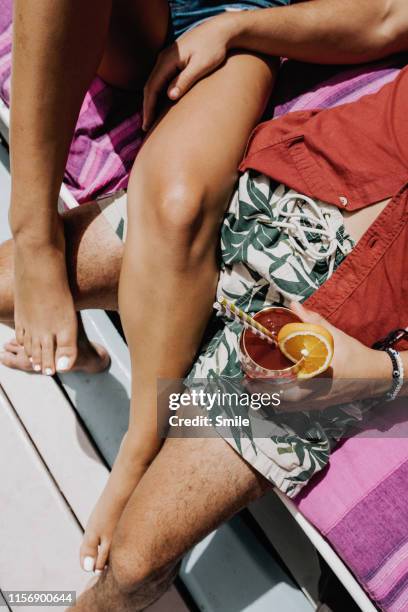 close up of couples legs intertwined outdoors at cocktail hour - hot wife stockfoto's en -beelden