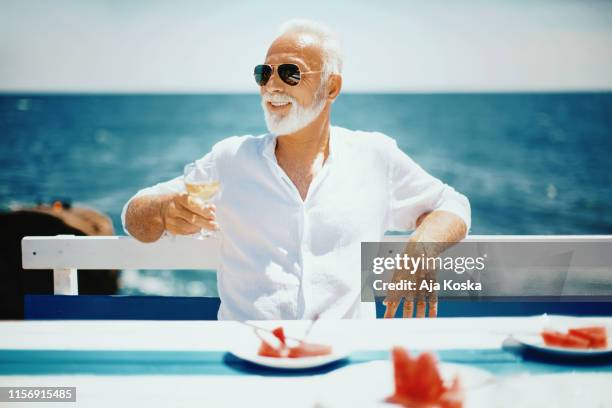 enjoying summer vacation. - senior men cafe stock pictures, royalty-free photos & images