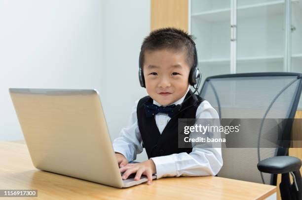 little operator works on laptop and recieves phone calls on headset - adult imitation stock pictures, royalty-free photos & images