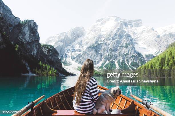 woman and dog in the boat on lago di braies in dolomites alps - pragser wildsee stock pictures, royalty-free photos & images