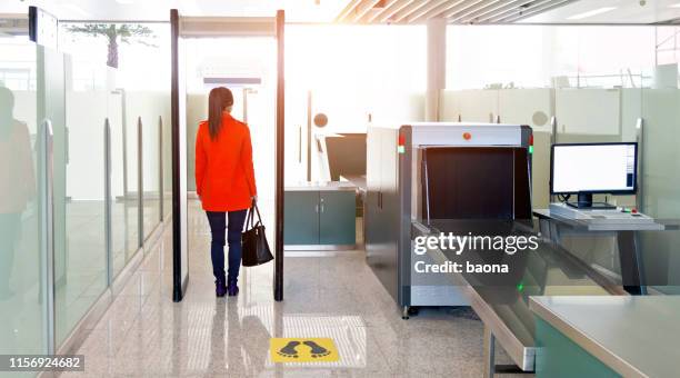passeggera donna che cammina attraverso il checkpoint di sicurezza dell'aeroporto - control pants foto e immagini stock
