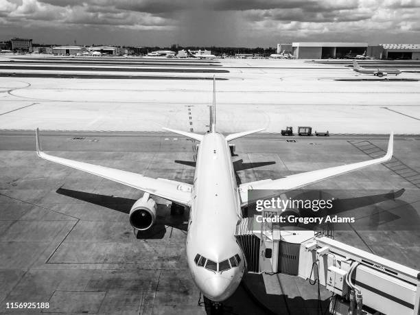 black and white photograph of a commercial airplane waiting at the gate - atlanta airport stock pictures, royalty-free photos & images