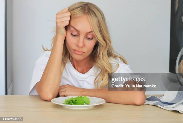 i'm fed up with untasty disgusting salad. close up unhappy grimacing sad upset lady looking down at plate of lettuce on table. - beautiful fat women stockfoto's en -beelden