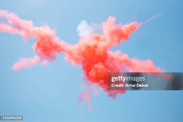 beautiful red powder explosion in the sky. - coloured smoke stock-fotos und bilder