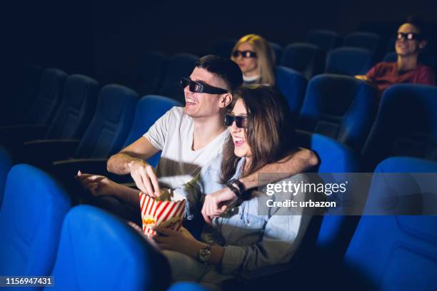 love couple in the cinema watching a movie - young couple at movie together imagens e fotografias de stock