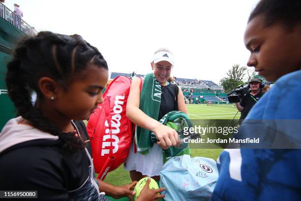 Jelena Ostapenko of Latvia signs autographs after victory in her second round match against Johanna Konta of Great Britain during day three of the...