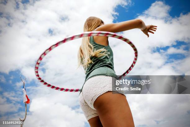 long woman hula hooping on blue cloudy skies - womens bottoms fotografías e imágenes de stock