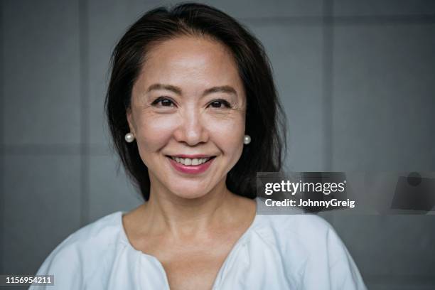 femme chinois aîné attirant souriant - visage chinois photos et images de collection