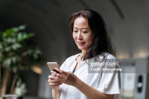 portrait of senior woman using smartphone - scrolling stock pictures, royalty-free photos & images