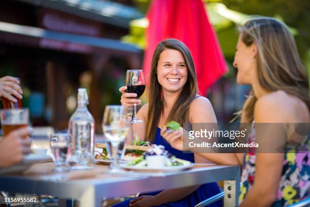 vrouw genieten van een drankje met vrienden op patio - restaurant patio stockfoto's en -beelden