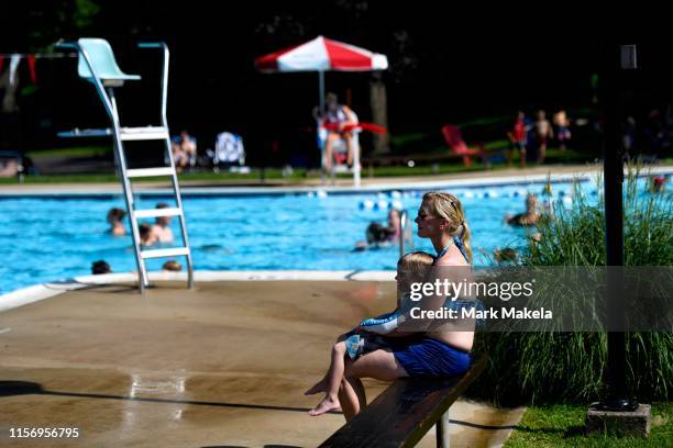 July 20: A mother holds her son while watching her other children swim at Karakung Swim Club on July 20, 2019 in Ardmore, PA. With heat indexes...