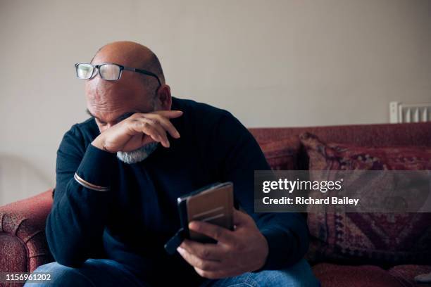 indian sikh man looking at mobile phone. - bald man crying stock pictures, royalty-free photos & images