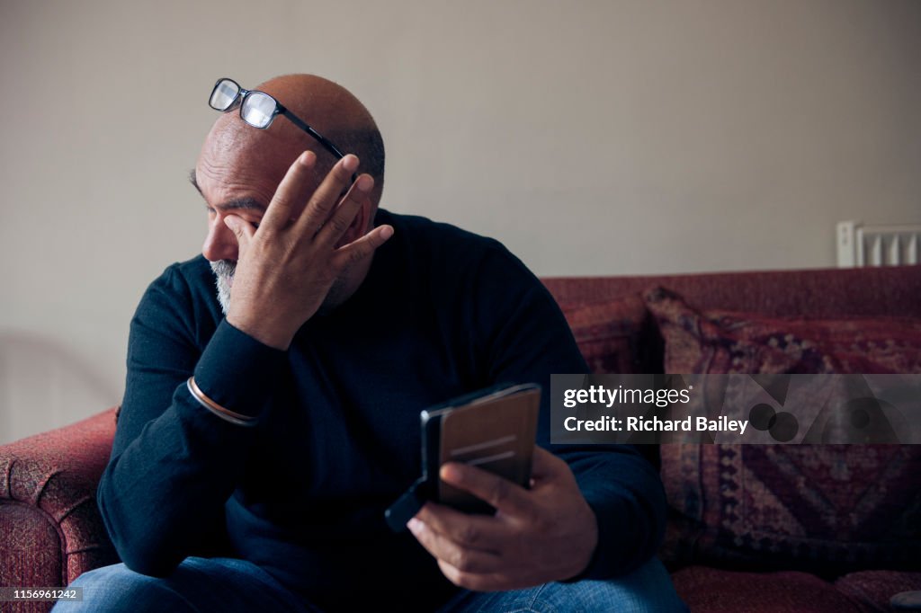 Indian Sikh man looking at mobile phone.