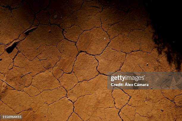 tierra anaranjada y agrietada por la sequía en verano - sequía - fotografias e filmes do acervo