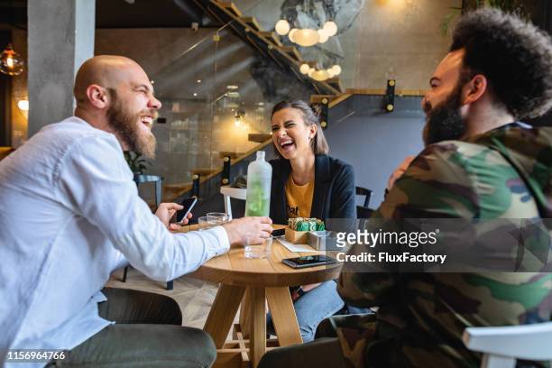 friends laughing at local coffee shop - round table imagens e fotografias de stock
