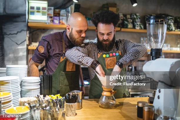 barista training a new employee how to make coffee in glass carafe - chef logo stock pictures, royalty-free photos & images