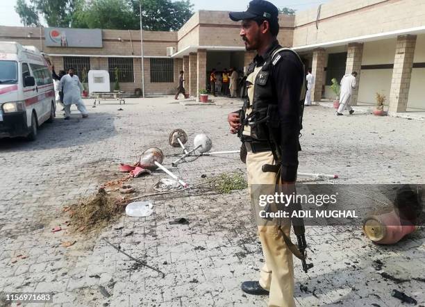 Pakistani policeman stands guard at site of a suicide bomb attack a hospital entrance in Kotlan Saidan village on the outskirts of the northwestern...