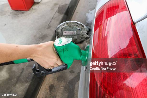 Woman filling a silver Suzuki Swift car with petrol at a Auchan gas station is seen in Gdansk, Poland on 21 July 2019 According to forecasts of the...