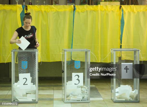 Woman throws her ballot into the polling box at the station during the parliamentary elections in Kiev, Ukraine, 21 July 2019. Ukraine votes for the...