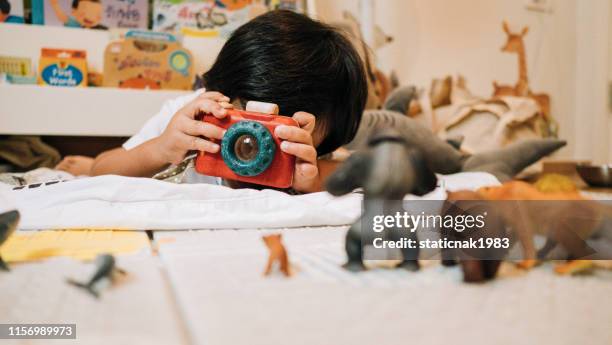 asian toddler girl photographer playing with toy camera. - toy camera stock pictures, royalty-free photos & images