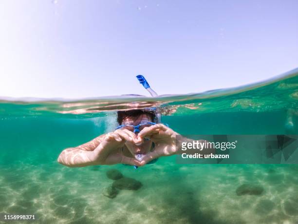 snorkeling e divertimento in mare - half underwater foto e immagini stock