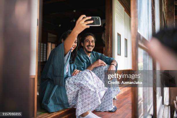 mixed race guests creating selfie at tokyo ryokan - japan tourist stock pictures, royalty-free photos & images