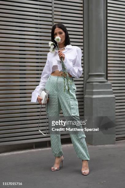 Guest is seen on the street attending Men's Paris Fashion Week wearing Off-White outfit with white top and sea green cargo pants on June 19, 2019 in...