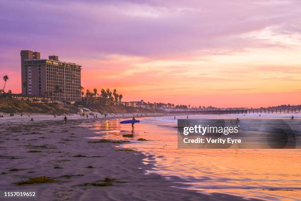surfers and pink sunset at pacific beach - san diego pacific beach stock pictures, royalty-free photos & images