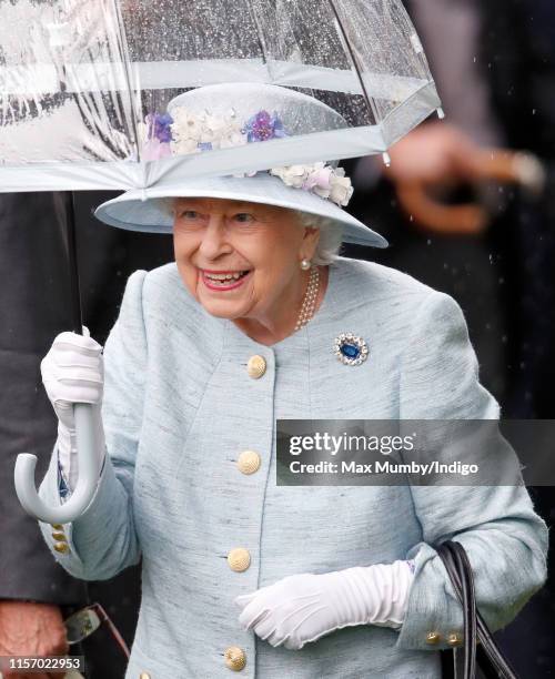 Queen Elizabeth II shelters under an umbrella as she attends day two of Royal Ascot at Ascot Racecourse on June 19, 2019 in Ascot, England.