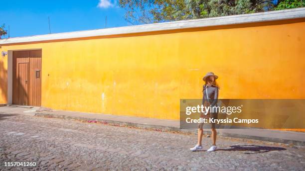 beautiful girl wearing hat walking at streets of antigua guatemala - orange hat stock pictures, royalty-free photos & images