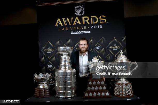 Ryan O'Reilly of the St. Louis Blues poses with the Frank J. Selke Trophy, the Stanley Cup, the Conn Smythe Trophy and the Lady Byng Memorial Trophy...