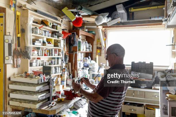 senior man werkt in zijn atelier - mancave stockfoto's en -beelden