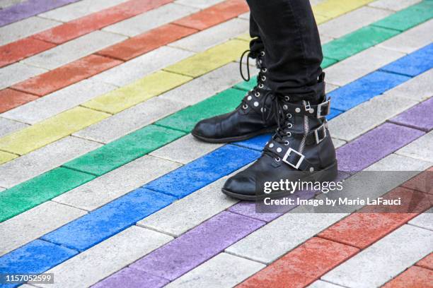 person standing on colorful rainbow sidewalk - leather boots stock pictures, royalty-free photos & images