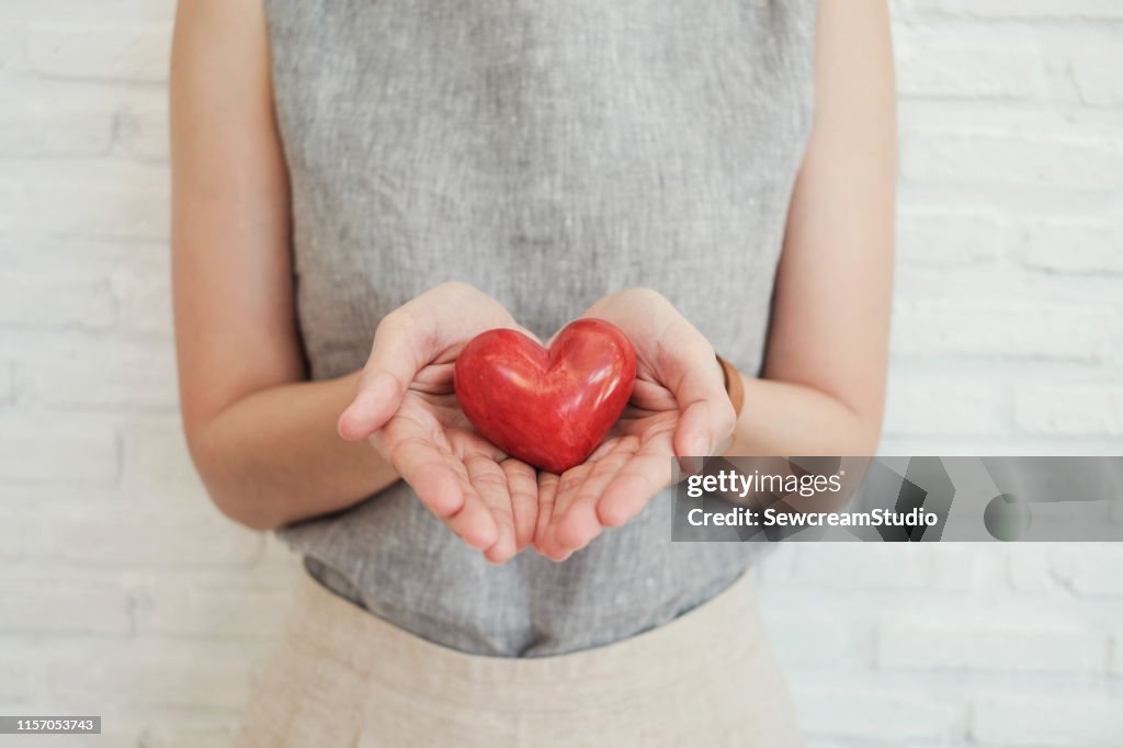 Woman holding red heart, health insurance, donation charity concept