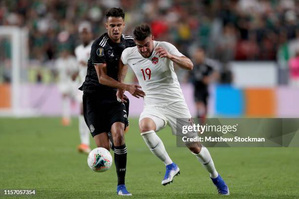 Diego Reyes of Mexico fights for the ball against Lucas Cavallini of Canada in the first half during group play in the CONCACAF Gold Cup at Sports...