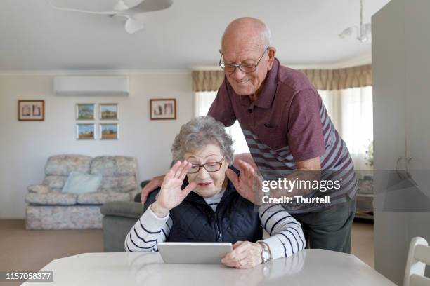 senior australian couple learning to use digital tablet - silver surfer stock pictures, royalty-free photos & images