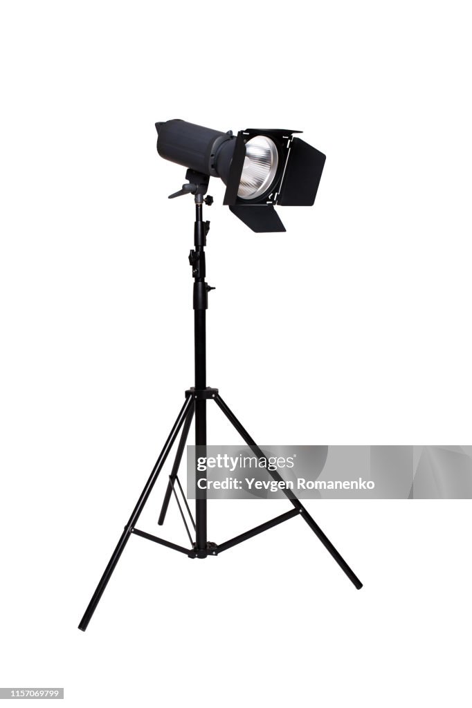 Studio flash light on a tripod stand isolated on white background
