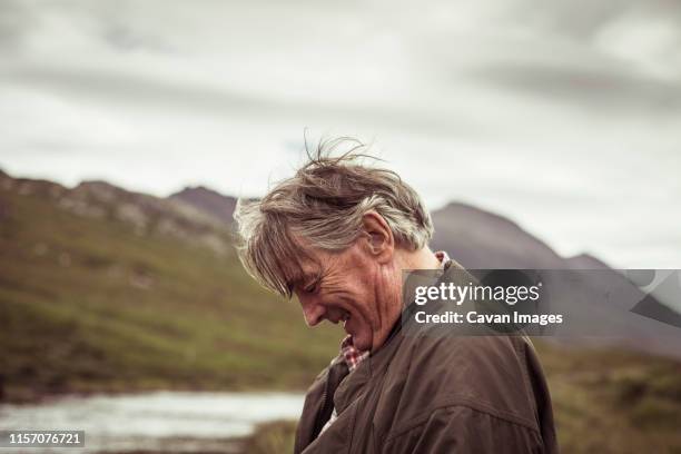 retired man laughs and smiles out fishing in remote river mountian - child silhouette ocean stock pictures, royalty-free photos & images